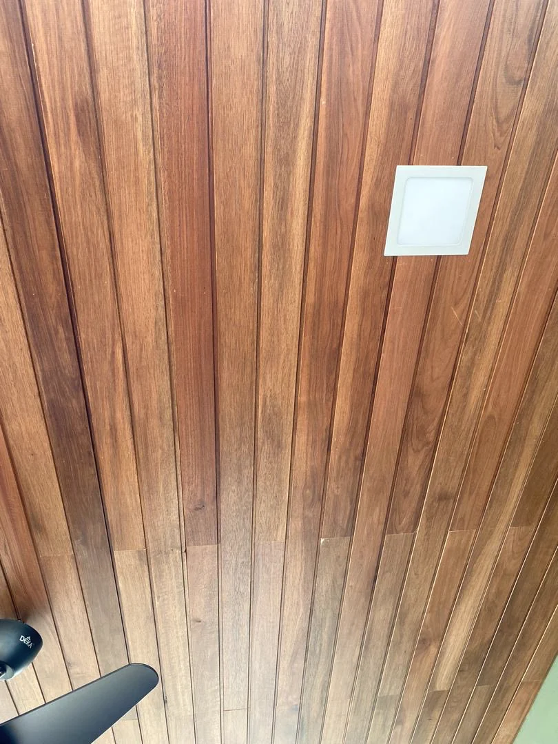 Installed solid wood ceiling boards with an integrated square light fitting